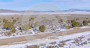 DRONE: Flying along a silver SUV cruising down the empty motorway crossing Utah.