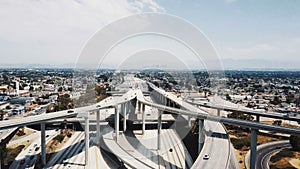 Drone flying forward over epic multiple level highway intersection in Los Angeles, traffic moving in all directions.