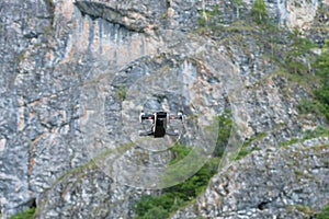 Drone flying with mounted digital camera used for photographing and filming. quadcopter flying hovering over mountains