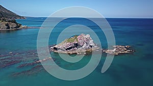 Drone is flying over beautiful rocks in water of Mediterranean sea near shore, top view