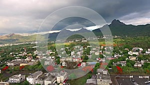 Drone flying over the Belle Etoile town in Mauritius, close to Port Louis. Stormy Sky and mountain in Background