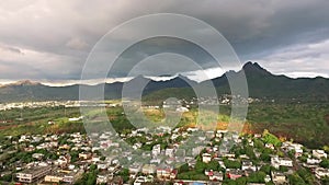 Drone flying over the Belle Etoile town in Mauritius, close to Port Louis. Stormy Sky and mountain in Background