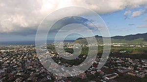 Drone flying over the Belle Etoile town in Mauritius, close to Port Louis. Stormy Sky and mountain in Background