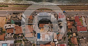 Drone flying over buildings of Colombo, Sri Lanka towards seashore. Aerial top view of Asian resort town and ocean.