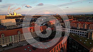 Drone flying over Copenhagen cityscape with river at sunset and factory's chimneysn Denmark