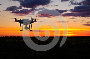 Drone is flying over the field at sunrise.