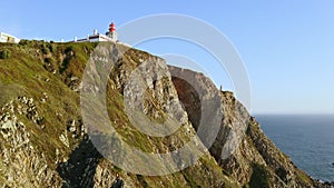 Drone flying over high hill rocks top view Atlantic ocean shores around cape Cabo da Roca in Sintra Portugal lighthouse