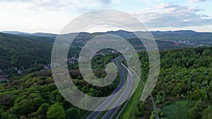 Drone flying over highway towards Walbrzych city in mountain green hills