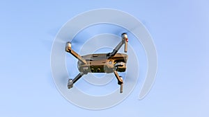 Drone flying over landscape. UAV drone copter flying with digital camera. Drone flying overhead in cloudy blue sky. Quad copter is