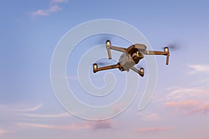 Drone flying over landscape. UAV drone copter flying with digital camera. Drone flying overhead in cloudy blue sky. Quad copter is