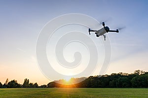 Drone flying over landscape. UAV drone copter flying with digital camera. Drone flying overhead in cloudy blue sky. Quad copter is