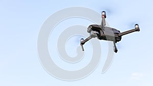 Drone flying over landscape. UAV drone copter flying with digital camera. Drone flying overhead in cloudy blue sky. Quad copter is