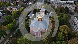 Drone is flying over a small church surrounded by trees in Daugavpils, Latvia 4k