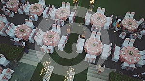 Drone flying over wedding dinner decoration, or marriage anniversary, in the garden outdoor, catering setting chairs and