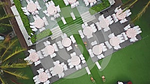 Drone flying over wedding dinner decoration, or marriage anniversary, in the garden outdoor, catering setting chairs and