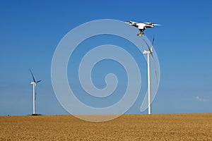 Drone flying over wheat field with wind turbine