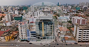 Drone flying right over Colombo, Sri Lanka. Aerial view of cityscape with buildings, street traffic and small railroad.