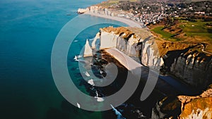 Drone flying very high above amazing azure sea shore with epic white chalk cliff coastline and sunset waves near Etretat