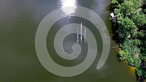 Drone follow four crew rowers in a boat on river
