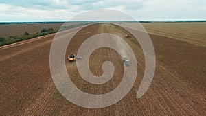 Drone footage of agricultural tractor working in field, aerial view of machinery on plantation