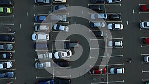 Drone footage cars parking at congested parking lots. people walking parking