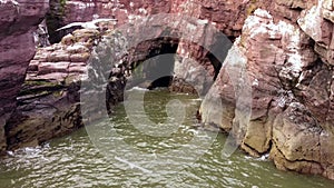 Drone footage of a cave in the Arbroath Cliffs at low tide.