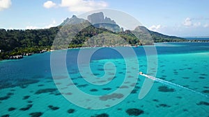 Drone footage of a cruising boat and Mount Otemanu in Bora Bora, Tahiti.