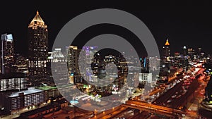 Drone footage of flowing highway traffic at night under the electric Atlanta skyline