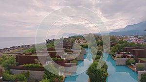 Drone footage of the hotel courtyard. Vacation at the resort. Green shrubs. Mountains in the background