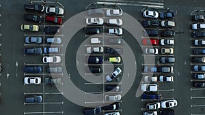 Drone footage people moving at parking. Aerial view car leaving parking