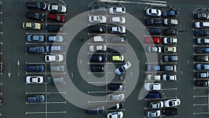 Drone footage people moving at parking. Aerial view car leaving parking