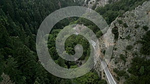 Drone footage of a twisty mountain road and green dense forest