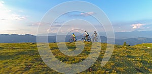 DRONE: Group of friends cross country cycling pedalling their bicycles uphill.