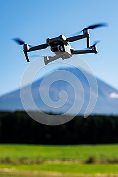 Drone hovering in front of Mount Fuji under clear sky