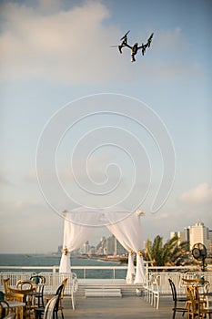 Drone hovering in the sky above the chuppah before the Jewish wedding ceremony against the backdrop