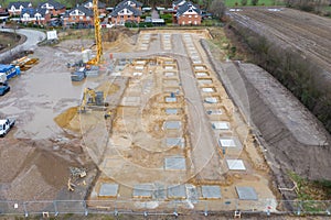 Drone image of a large construction site on which the concrete foundation for the columns of a factory building is being cast