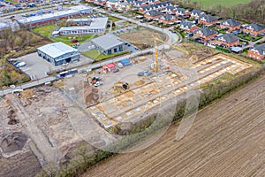 Drone image of a large construction site on which the concrete foundation for the columns of a factory building is being cast