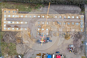 Drone image of a large construction site on which the concrete foundation for the columns of a factory building is being cast