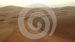 Drone, landscape and man on a desert hill at sunset in Namibia for adventure, exploring and journey. Travel, horizon and