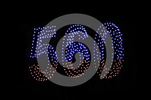 Drone light shows on black night sky background. A figure of the number five hundred and sixty, six, five, zerro, 560