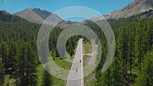 DRONE: Motorcycle riders cruising along a scenic road in French countryside.