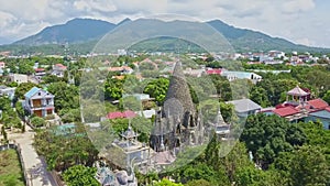 Drone moves to coral Buddhist temple tower against hill