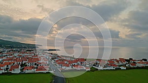 Drone ocean country houses in cloudy evening. Peaceful cape landscape on sunset.
