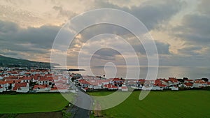 Drone ocean country houses in cloudy evening. Peaceful cape landscape on sunset.