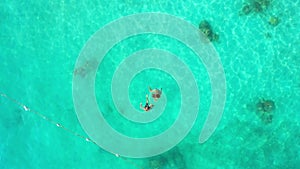 Drone, ocean and people swimming in sea on summer, holiday or island vacation in Malaysia. Turquoise, water and couple