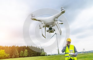 Drone operated by construction worker inspecting wind turbine
