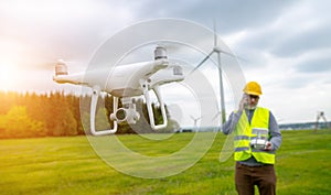 Drone operated by construction worker inspecting wind turbine