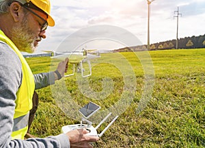 Drone operated by construction worker inspecting wind turbine