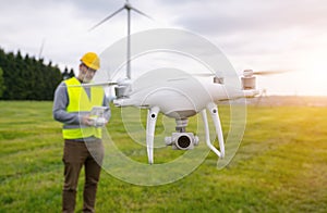 Drone operated by construction worker inspecting wind turbine