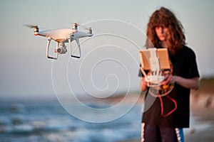 Drone operated by young man flying over an sea